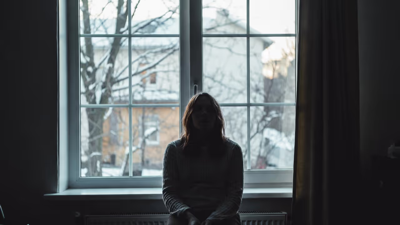 Adult sitting indoors during winter light with low mood
